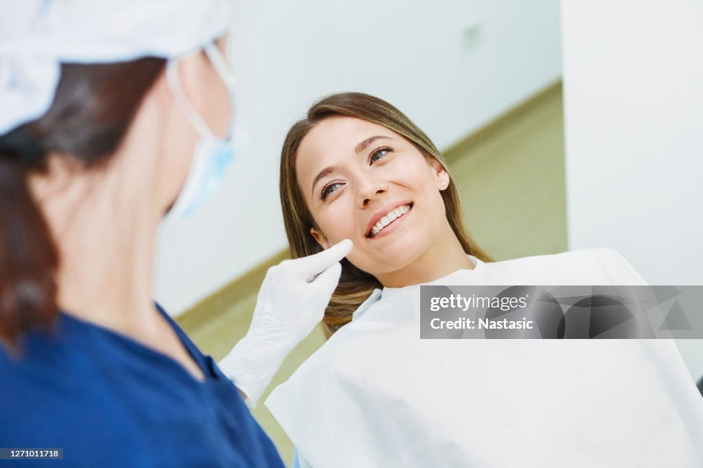 Dentista donna che parla con una paziente spiegando la procedura