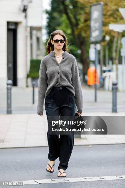 Influencer Jacqueline Zelwis wearing a grey cardigan by Gestuz, black pants by Holzweiler, black Flip Flops by Havainas, a black bag by Prada,...