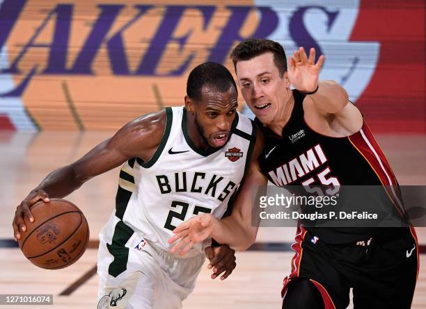 Khris Middleton of the Milwaukee Bucks drives the ball against Duncan Robinson of the Miami Heat during the fourth quarter in Game Four of the...