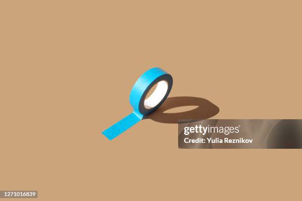 one blue masking tape on the beige background - sticky stock pictures, royalty-free photos & images