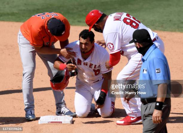Franklin Barreto of the Los Angeles Angels is helped by Aledmys Diaz of the Houston Astros and Jose Moina after an injury while stealing second base...
