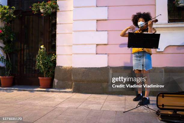 afroamerikanische straßenmusiker tragen gesichtsmasken, die in zeiten der pandemie musik spielen - masked musicians stock-fotos und bilder