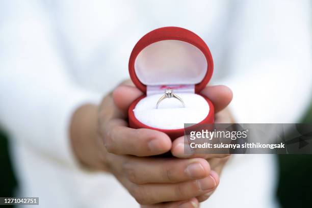 midsection of couple showing engagement ring on hand. - ring box stock-fotos und bilder