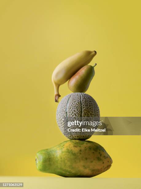 pieces of fruit balancing - food sculpture stock pictures, royalty-free photos & images