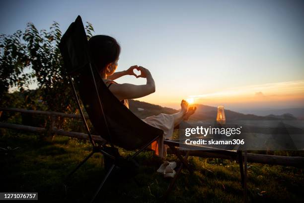 female young adult happy with climate and sunset and camping outdoor lifestyle - camping de lujo fotografías e imágenes de stock