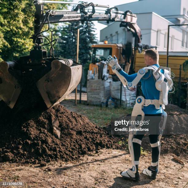 upgraded, super worker is working on the construction site. - exoskeleton stock pictures, royalty-free photos & images