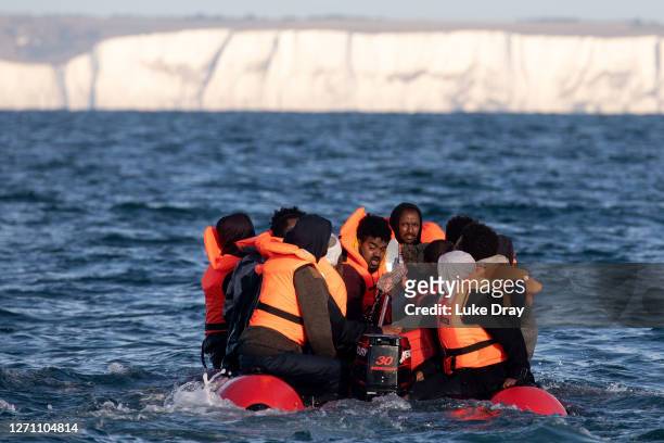 Migrants packed tightly onto a small inflatable boat attempt to cross the English Channel near the Dover Strait, the world's busiest shipping lane,...