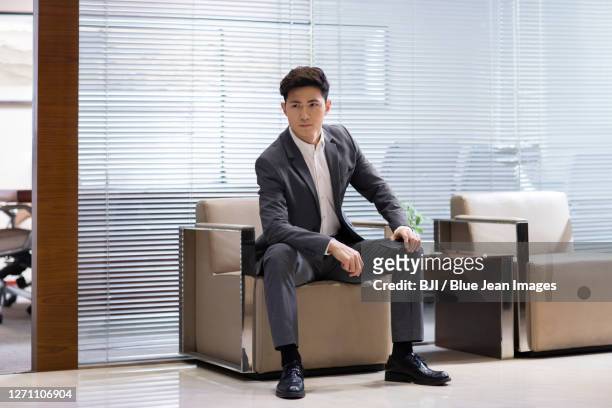 confident businessman holding smartphone in office - colarinho aberto imagens e fotografias de stock