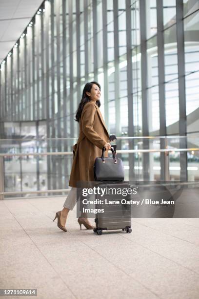 young businesswoman in airport - business woman suitcase stockfoto's en -beelden