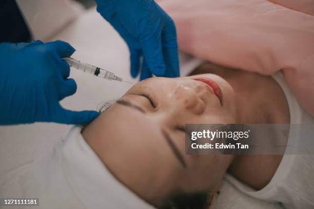 顔の美容院で顔に注射を受けるアジアの中国の女性 - facelift ストックフォトと画像