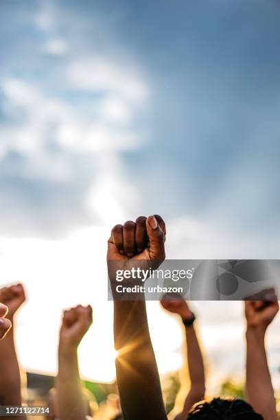 demonstranten die vuisten opheffen - clenched fist stockfoto's en -beelden