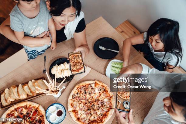 family sharing meal together, photographing food using smart phone - chinese family taking photo at home stock pictures, royalty-free photos & images