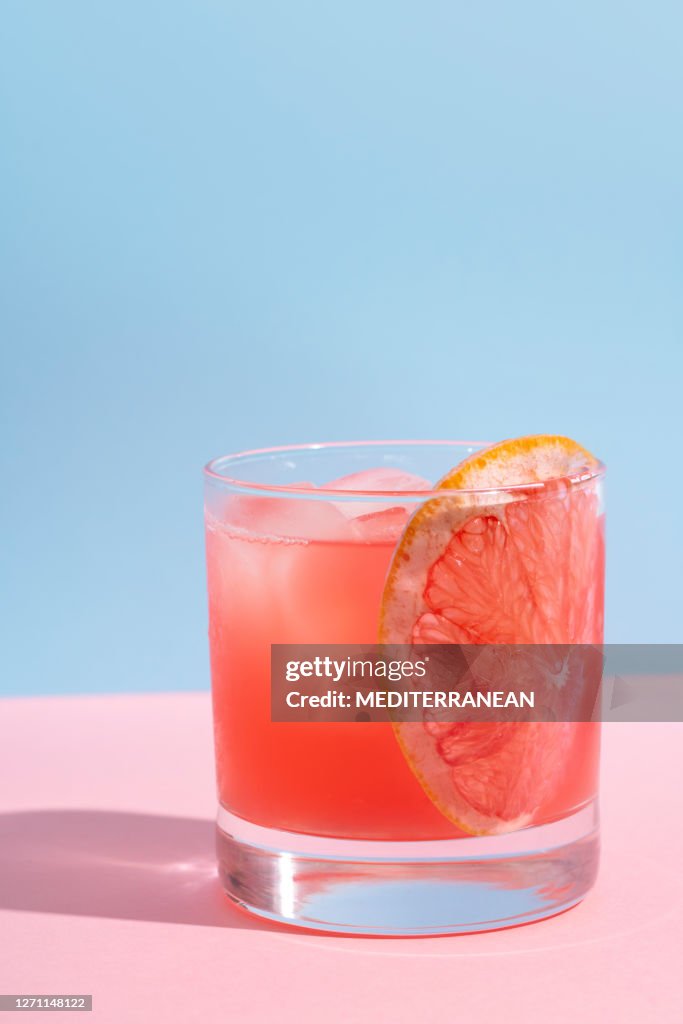 Grapefruit cocktail on pink table and blue wall summer drink