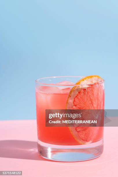 coquetel de toranja na mesa rosa e bebida de verão de parede azul - orange color - fotografias e filmes do acervo