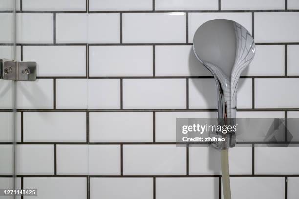 shower on the bathroom wall - bathroom closeup stockfoto's en -beelden