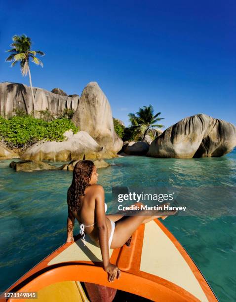 beautiful woman relaxing on boat on a tropical island paradise. anse source d' argent beach la digue island seychelles. - coconut beach woman stock pictures, royalty-free photos & images