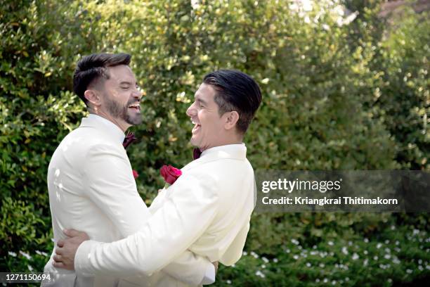 same sex couple having a laugh at the wedding day. - civil partnership stock pictures, royalty-free photos & images