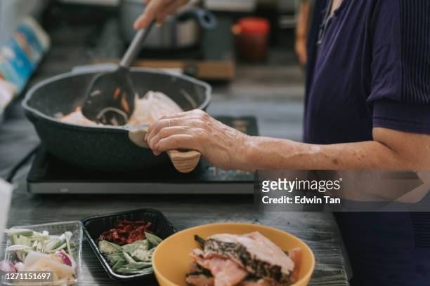 asian chinese senior woman preparing meal and cooking food turnip in kitchen - crucifers stock pictures, royalty-free photos & images