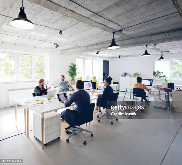 business professionals working at new office desk - grande angular imagens e fotografias de stock