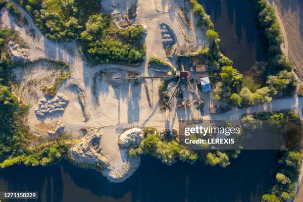 aerial view of a quarry machine from the sand mine and the lake around it - open pit mine stock pictures, royalty-free photos & images