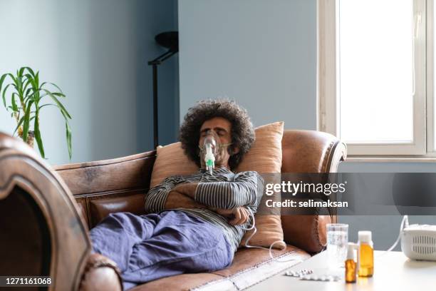 reife erwachsene mann mit vernebler zu hause - mukoviszidose stock-fotos und bilder