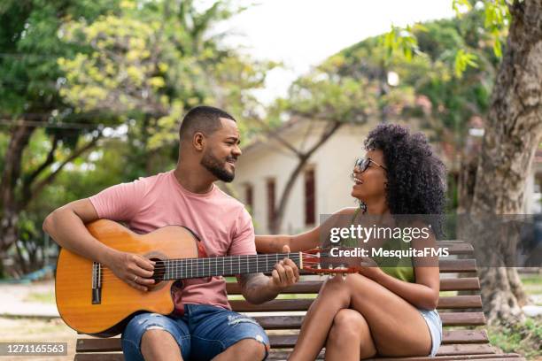 casal tocando violão na praça com a namorada - praça - fotografias e filmes do acervo