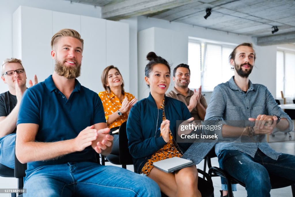 Smiling business colleagues clapping at workplace