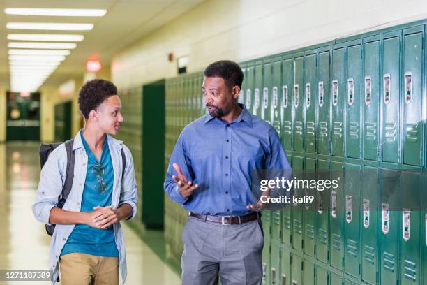 teacher and high school student walking in hallway - principal stock pictures, royalty-free photos & images