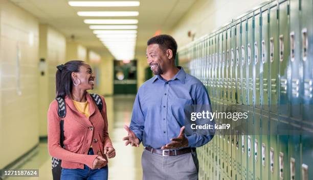 teacher and high school student walking in hallway - school principal stock pictures, royalty-free photos & images