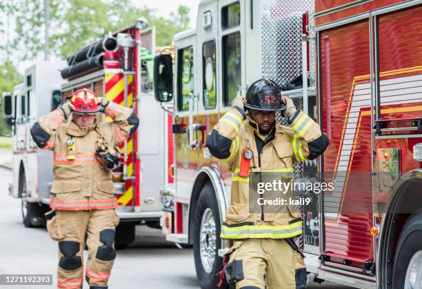 two firefighters ready for action - firefighter getting dressed stock pictures, royalty-free photos & images