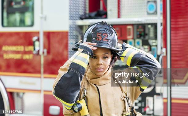 feuerwehrfrau im brandschutzanzug - feuerwehrhelm stock-fotos und bilder