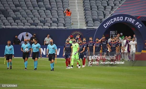 Members of the Chicago Fire and the New England Revolution enter the pitch before a match at Soldier Field on September 06, 2020 in Chicago, Illinois.