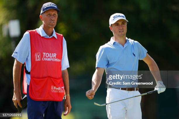 Justin Thomas of the United States talks with his caddie Jim "Bones" Mackay 0n the 11th tee during the final round of the TOUR Championship at East...