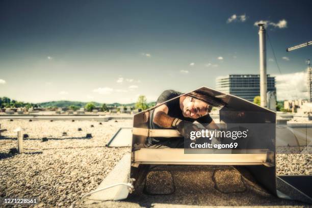 chimney sweeper cleaning a chimney - chimney sweep stock pictures, royalty-free photos & images