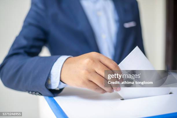 ballot box with person casting vote. - voting booth stock pictures, royalty-free photos & images