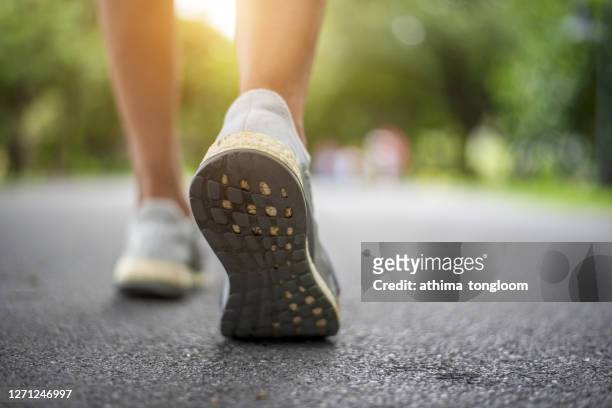 close up shot of runner's shoes - gehen stock-fotos und bilder