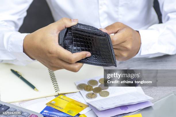 close up man hand opening wallet over calculator , debt expense bills monthly and credit card at the table in home office , managing payroll,money risk financial concept - dolours price stock pictures, royalty-free photos & images