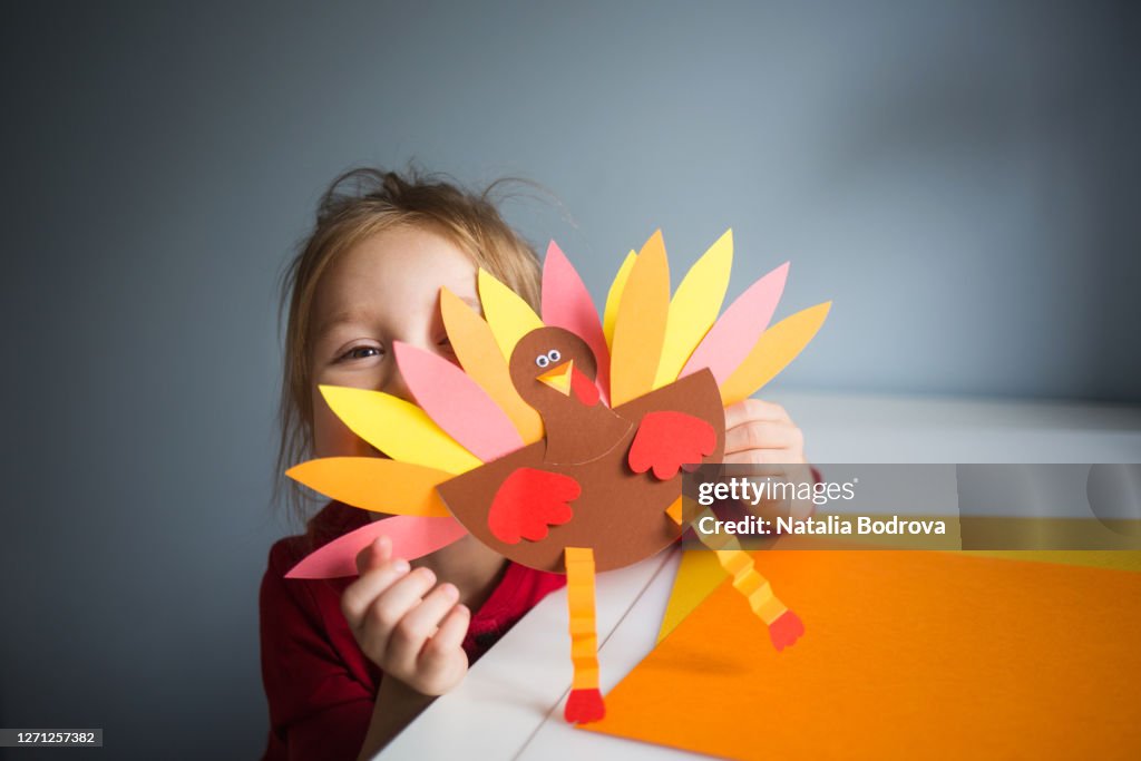 Paper craft for kids. DIY Turkey made for thanksgiving day. create art for children. girl playing with a toy