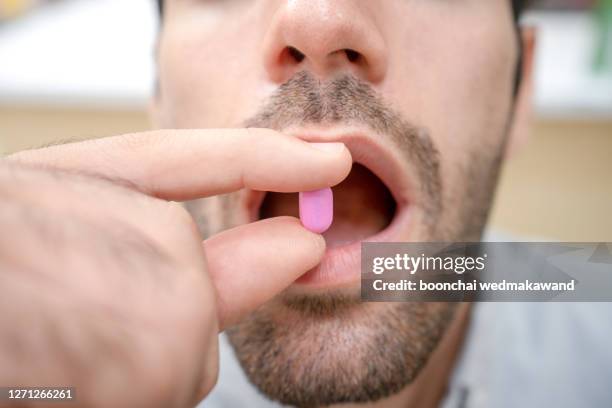 man taking medication - males photos et images de collection