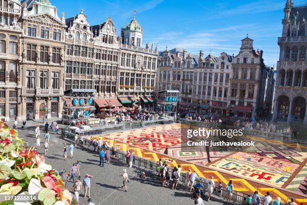vista aérea de la mitad grand place en bruselas con alfombras de flores y edificios - grand place brussels fotografías e imágenes de stock