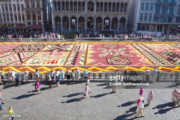 tourists and le tapis de fleurs on grand place in brussels - adult man brussels stock pictures, royalty-free photos & images