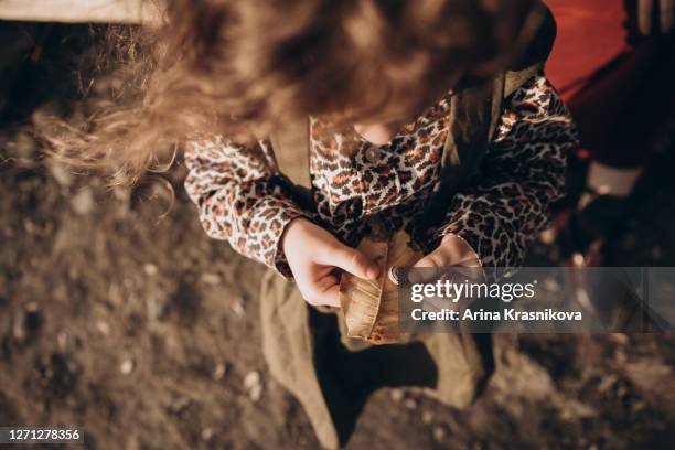 little girl holding a yellow leaf - moment collection stockfoto's en -beelden