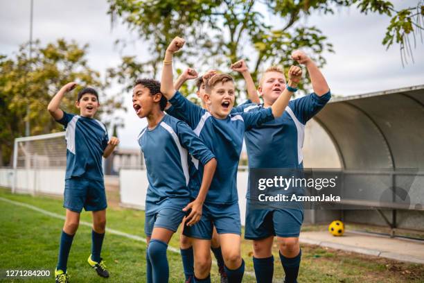 dedicated boy voetballers ponsen de lucht in ondersteuning - side lines stockfoto's en -beelden