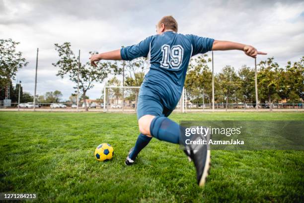 gran construcción pre-teen boy footballer approaching ball to kick - chubby boy fotografías e imágenes de stock