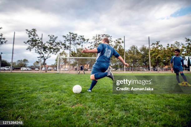 grote build pre-teen boy voetballer naderende bal om kick - chubby teen stockfoto's en -beelden