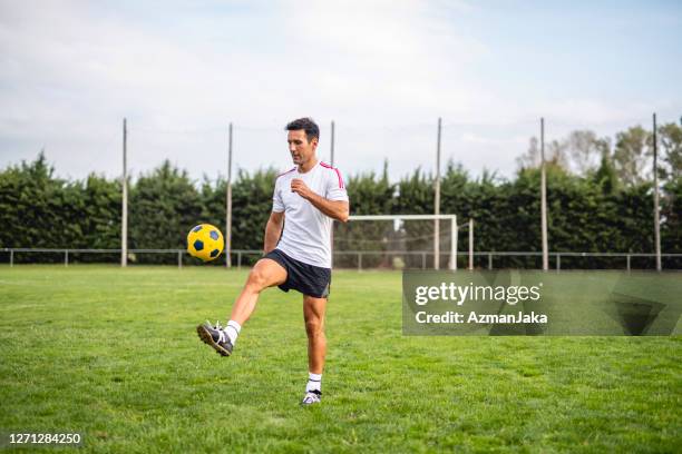 mature male footballer practicing juggling for ball control - malabarismo imagens e fotografias de stock