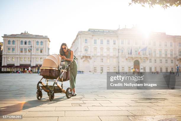 young italian woman walking with her baby - baby stroller imagens e fotografias de stock