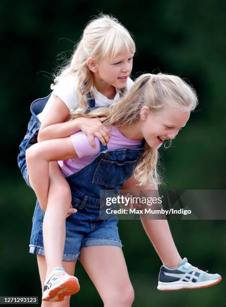 Savannah Phillips gives her sister Isla Phillips a piggyback as they attend day 1 of the 2019 Festival of British Eventing at Gatcombe Park on August...