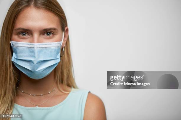 portrait of young female wearing protective face mask - face mask protective workwear imagens e fotografias de stock