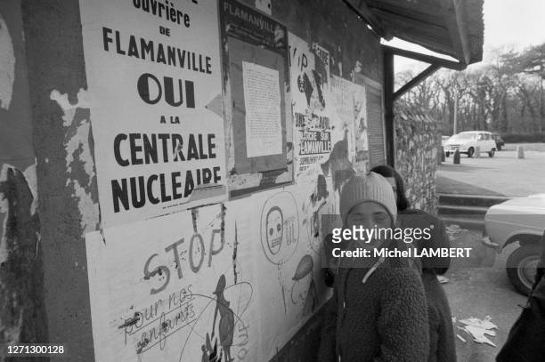 Enfants devant un panneau d'affichage public lors du référendum sur la construction d'une centrale nucléaire à Flamanville, le 6 avril 1975.